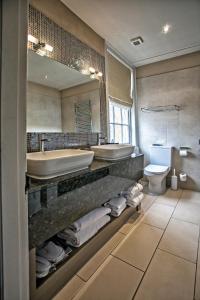 约克Grays Court Hotel的一间带两个盥洗盆、浴缸和卫生间的浴室