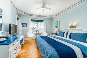 Saint-Laurent-de-l'ile d'OrleansGoéliche hotel et appartement的一间蓝色卧室,配有一张床和电视
