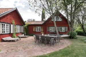 VårstaBjörnbacka- Chillout Oasis on the Countryside Near Stockholm的红色谷仓前带桌椅的天井