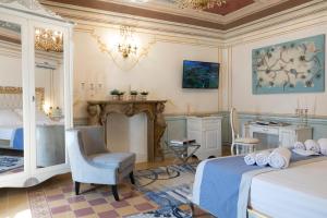 萨萨里Les Suite Royales的一间卧室设有两张床、一把椅子和壁炉