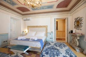 萨萨里Les Suite Royales的一间卧室配有一张床和一个吊灯