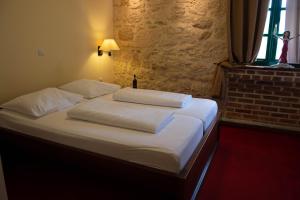 比奥格勒·纳·莫鲁卡尔皮摩尔酒店的一间卧室配有带白色床单和枕头的床。
