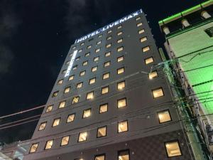 东京HOTEL LiVEMAX Shinjuku Kabukicho的一座高大的建筑,上面有灯