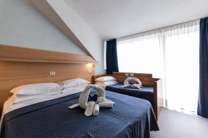 利尼亚诺萨比亚多罗Hotel Mimosa的在酒店房间设有两张床,里面装满了动物