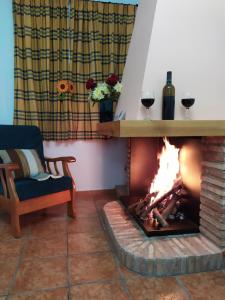 阿罗约弗里奥Alojamiento valeria的壁炉,房间里放着两杯葡萄酒
