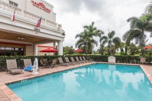 西棕榈滩Hawthorn Extended Stay by Wyndham West Palm Beach的游泳池,带椅子和遮阳伞