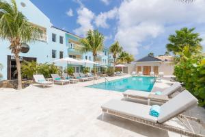 威廉斯塔德Dolphin Suites & Wellness Curacao的一座别墅,设有游泳池和棕榈树