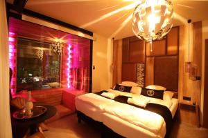 希欧福克Baobab Suites的一间卧室配有一张带粉红色灯的大床