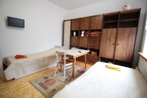 RamučiaiDangus的一间卧室配有一张床、一张桌子和一张床