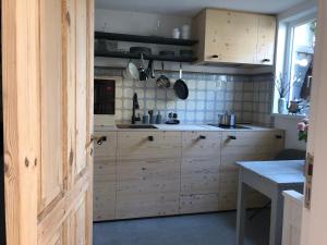 不莱梅Bremerraumnatur的厨房配有木制橱柜、桌子和窗户。