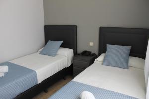马德里巴拉哈斯广场酒店的一间卧室配有两张床,内配电话