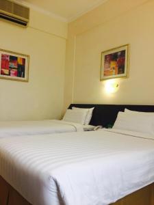 马斯喀特地那假日酒店的两张睡床彼此相邻,位于一个房间里
