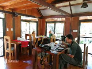 Comandante AndresitoSurucua Reserva & Ecolodge的坐在桌子上,有摄像头的人
