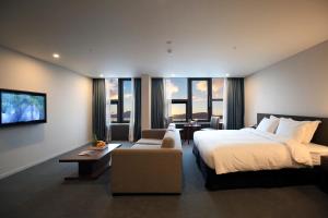 济州市济州贝斯特韦斯特酒店的酒店客房设有一张大床和一张沙发。