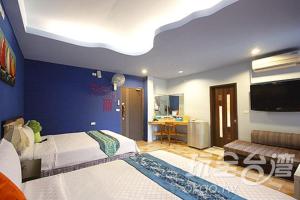 恒春古城幸福垦丁的一间卧室设有两张床和蓝色的墙壁