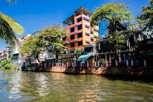 曼谷Bangkok Canale Home at Khaosarn的一条河,河的两边有一座建筑