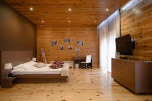 卢茨克Patio di Fiori的一间卧室设有木墙、一张床和电视。