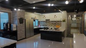 春川Sh Guesthouse的一间设有黑色橱柜和台面的大厨房