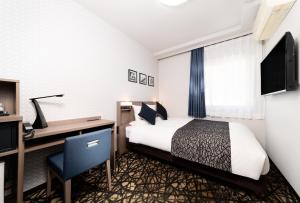 青森HOTEL MYSTAYS Aomori Station的配有一张床和一张书桌的酒店客房