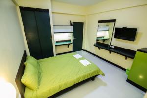 程逸府จุฑาแมนชั่น的一间卧室配有绿色的床和镜子