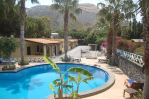 弗卡诺Hotel Al Togo Fitness & Relax的棕榈树屋前的游泳池