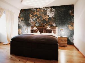 格拉茨Kaiser Apartments - City Centre of Graz的一间卧室配有一张带花卉壁纸的大床