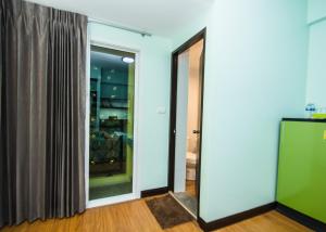 程逸府จุฑาแมนชั่น的一间设有滑动玻璃门和衣柜的房间