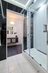 弗罗茨瓦夫Lux Apartment Center的一间带玻璃淋浴和水槽的浴室
