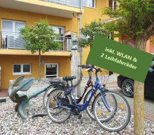 岑平Ferienresidenz zur Ostsee的两辆自行车停在大楼前的一个标志旁边