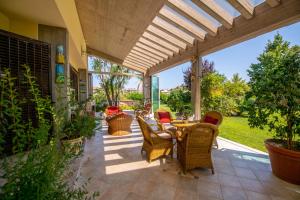 马帝斯兹罗Villa Tigli Luxury B&B的庭院配有藤椅和桌子