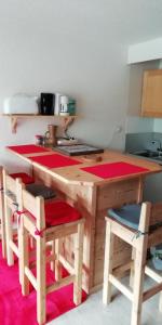 拉萨尔莱阿尔佩Le Galibier的厨房配有木桌和一些椅子