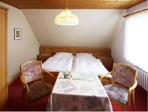 温特贝格布劳恩膳食公寓酒店的卧室配有一张床和一张桌子及椅子