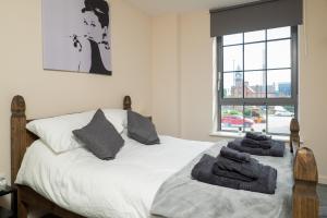 诺丁汉Stylish & Cosy Apartment的卧室配有白色床和毛巾