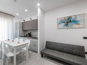 卡利亚里Diaz Apartment的厨房以及带桌子和沙发的用餐室。