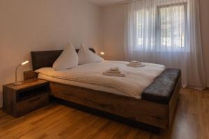 维尔德斯韦尔Chalet Gousweid- Mönch Apartment的一间卧室配有一张带白色床单的床和一扇窗户。