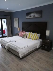 邦尼韦尔Christofphs的卧室配有带条纹枕头的白色大床