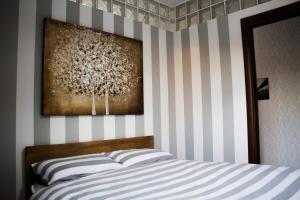米兰Res. Chalet a 10 min. da Rho Fiera e Stadio Meazza的一间卧室配有一张带条纹墙的床