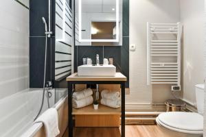 里尔Appart'City Confort Lille - Euralille的一间带水槽、浴缸和卫生间的浴室