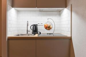 里尔Appart'City Confort Lille - Euralille的厨房柜台设有水槽和搅拌机