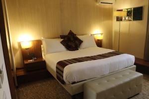 蒙罗维亚Mamba Point Hotel的酒店客房设有一张大床和两盏灯。