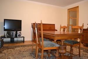 泰拉维Royal Telavi的一间带木桌和电视的用餐室