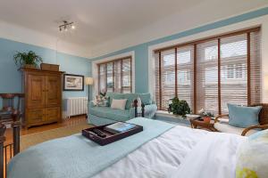 魁北克市Les Immeubles Charlevoix - Le Perchoir 1018的卧室拥有蓝色的墙壁,配有一张床和一张沙发