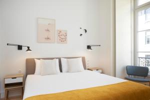 里斯本Montebelo Lisbon Downtown Apartments的卧室配有白色的床和蓝色椅子