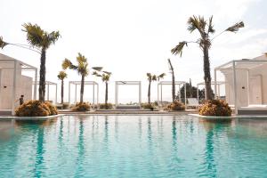 万隆装饰艺术豪华公馆酒店的一座棕榈树环绕的游泳池