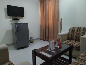 ShāhiqSuper OYO 107 Al Areen Hotel Apartments的客厅配有电视和茶几