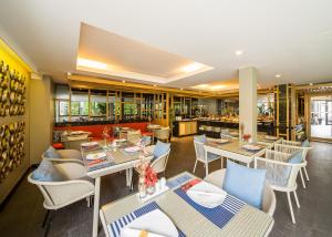 华欣华欣岩石豪华精品渡假酒店的一间带桌椅的餐厅和一间酒吧