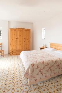 伊斯基亚Albergo Villa Mario的一间卧室配有一张大床和一个木制橱柜