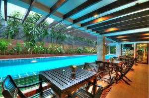 曼谷Aspen Suites Hotel Sukhumvit 2的游泳池旁带桌椅的游泳池