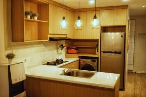三宝垄Graha Padma Avonia的厨房配有水槽和不锈钢冰箱
