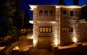 塞尼梅西奇卡罗梅赛翁酒店的一座大型石头建筑,晚上设有车库